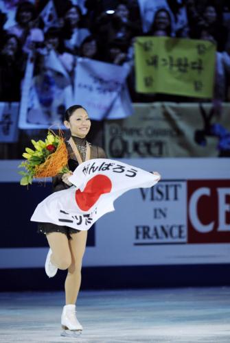 フィギュアスケートの世界選手権で２度目の優勝を果たし、「がんばろうニッポン」と書かれた日の丸を手に観客の声援に応える安藤美姫