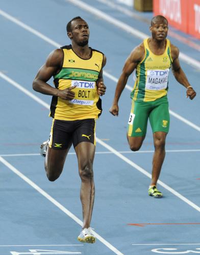 男子１００メートル予選　余裕のある走りでゴールする、１着で準決勝進出を決めたウサイン・ボルト（左）