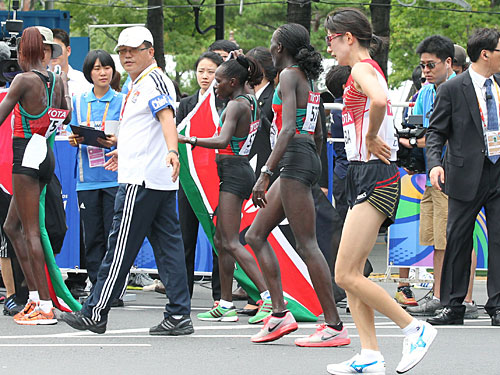 ＜女子マラソン＞ゴール後、国旗を持って喜ぶケニア勢の横で悔しそうな赤羽（右）