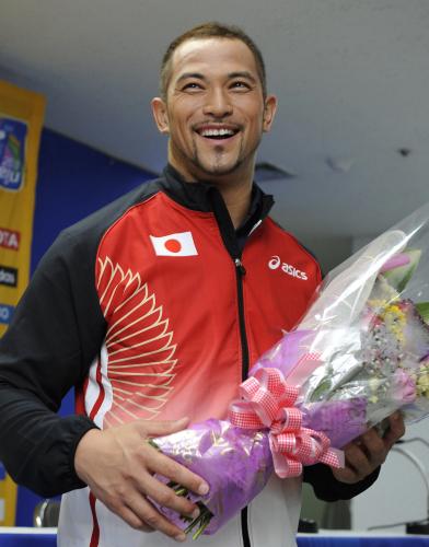 陸上の世界選手権男子ハンマー投げの優勝から一夜明け、花束を手に笑顔を見せる室伏広治