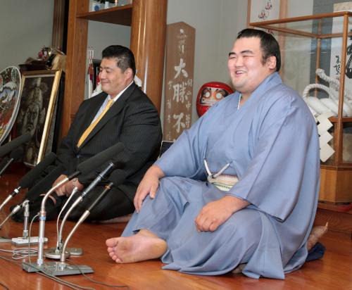 千秋楽から一夜明け、佐渡ケ嶽親方（左）と共に記者会見する笑顔の関脇琴奨菊