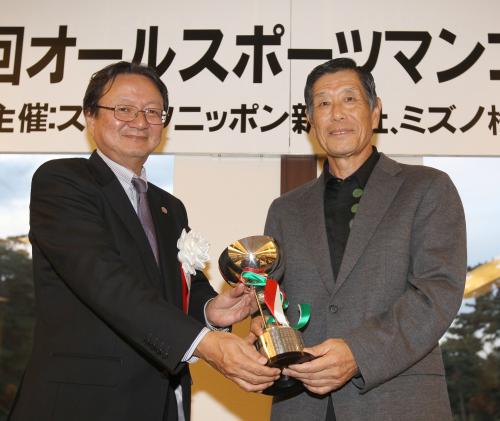 シニアの部で優勝したサッカーの横山謙三（右）は森戸スポニチ社長からカップを贈られる