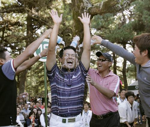優勝を決め、仲間のゴルファーから手荒い祝福を受ける武藤俊憲