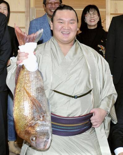 大相撲九州場所で21度目の優勝を果たし、タイを掲げ笑顔を見せる横綱白鵬