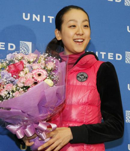 優勝したフィギュアスケートのロシア杯から帰国し、花束を贈られ笑顔の浅田真央