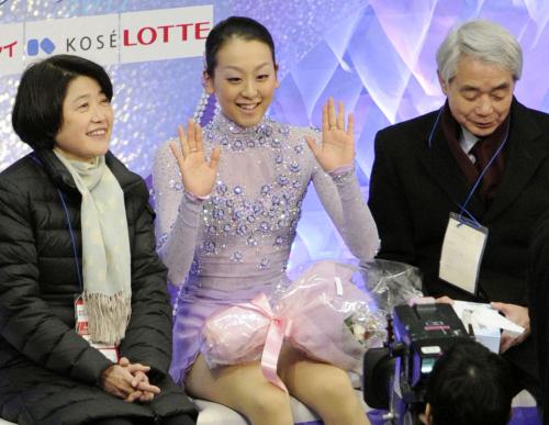女子フリーの演技を終え、笑顔で手を振る浅田真央選手。右は佐藤信夫コーチ