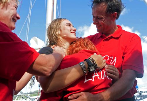 21日、シントマールテン島で、世界一周達成後に家族と抱き合うデッカーさん（左から２人目）