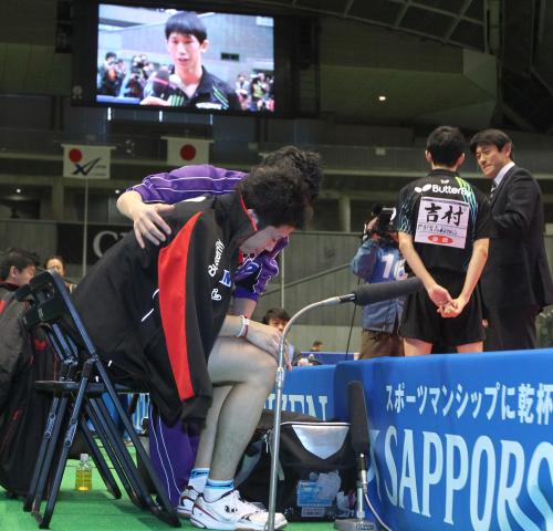 ＜卓球全日本選手権　男子シングルス＞６連覇を逃した水谷は優勝インタビューを受ける吉村の後方で肩を落とす