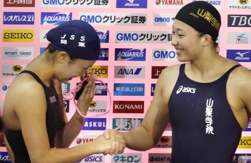 女子２００メートル平泳ぎで五輪代表入りを決め、涙ぐむ２位の渡部香生子（左）と握手する優勝の鈴木聡美