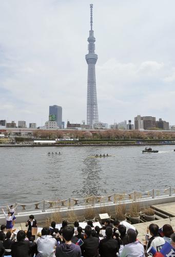 ２年ぶりに東京・隅田川に舞台を戻して行われた早慶レガッタに声援を送る人たち。後ろは東京スカイツリー