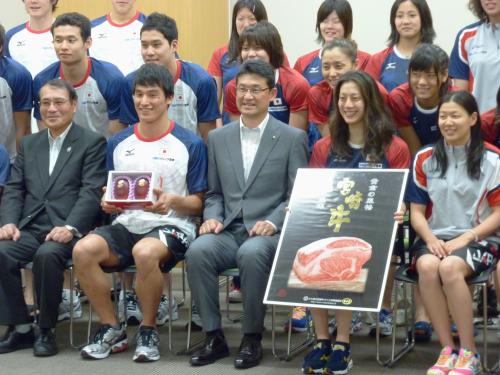 競泳のロンドン五輪代表チームに名産品のマンゴーなどを贈呈し、写真に納まる宮崎県の河野俊嗣知事（前列中央）。左隣は松田丈志