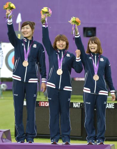 女子団体で銅メダルを獲得し、花束を手に笑顔の（左から）早川漣、蟹江美貴、川中香緒里