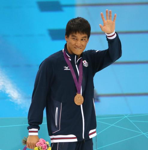 男子２００Ｍバタフライで２大会連続の銅メダルを獲得し、笑顔で声援に手を挙げる松田丈志