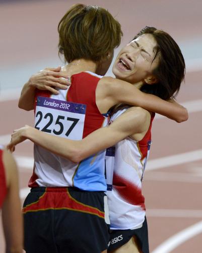 女子１万メートル　９位でゴールした新谷仁美（左）と抱き合って感極まった表情を見せる16位の吉川美香