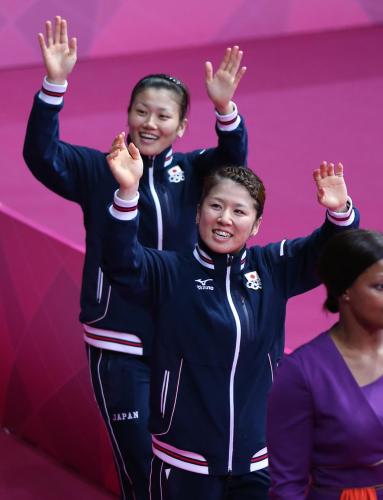 女子ダブルスで銀メダルを獲得し、スタンドの応援団に手を振る藤井（手前）と垣岩