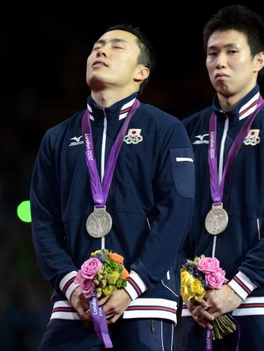 男子フルーレ団体の表彰台で、銀メダルを胸に優勝したイタリアの国歌を聞く太田。右は淡路