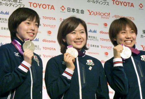 記者会見で銀メダルを手にポーズをとる卓球女子団体の（左から）石川佳純、福原愛、平野早矢香