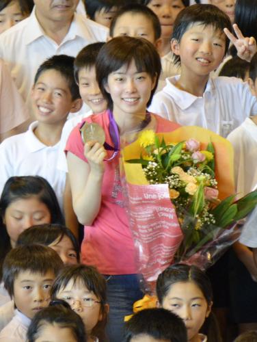 母校の平川小を訪れ、児童らに囲まれながら銀メダルを掲げる石川佳純選手