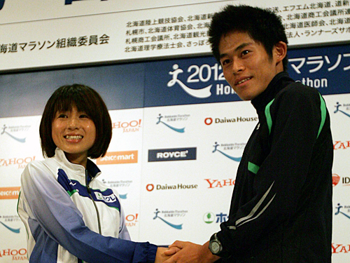 北海道マラソンの会見に出席した川内（右）は女子招待選手の鈴木と握手