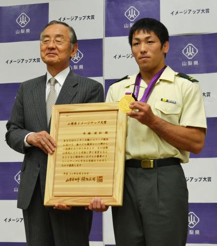 ロンドン五輪レスリング男子金メダリストの米満達弘（右）に山梨県のイメージアップ大賞を授与した横内正明知事