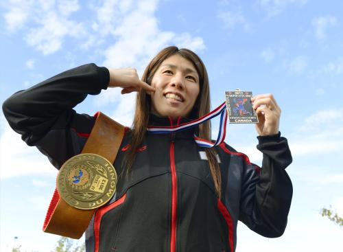 13大会連続世界一達成から一夜明け、金メダルと記念のベルトを手にポーズをとるレスリング女子55キロ級の吉田沙保里