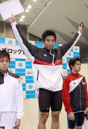 男子１００メートル平泳ぎで優勝し、表彰式で声援に応える山口観弘（中央）