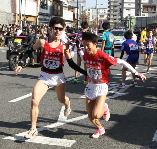 ６位でタスキリレーする帝京大４区・早川昇平（左）と５区・小山司