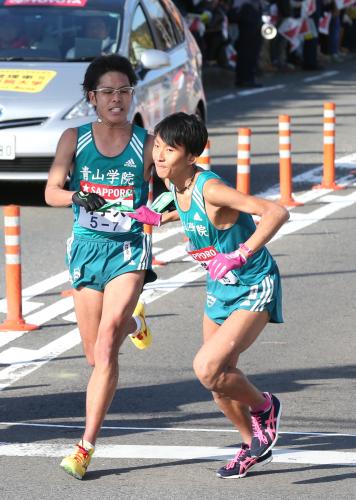 青学大・小椋（左）からタスキを受ける高橋。８区で区間賞となる快走を見せた