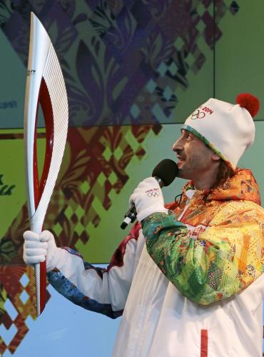 モスクワでソチ冬季五輪の聖火トーチを示すロシア人選手