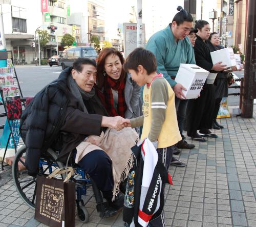 東日本大震災の被災者への募金活動を行う（左から）元横綱・大鵬の納谷幸喜さん芳子夫人