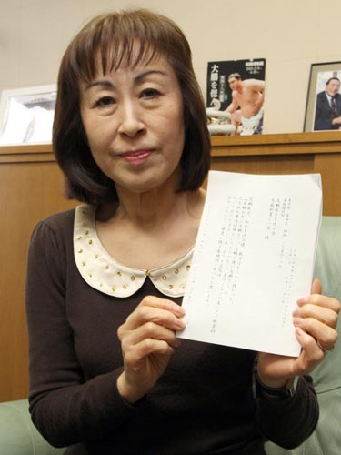 安倍首相から届いた電報を手にする芳子夫人