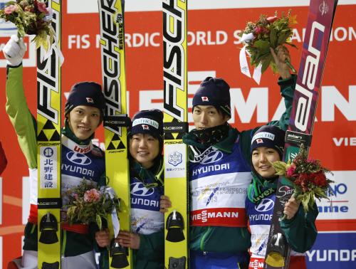 ノルディックスキー世界選手権のジャンプ混合団体で優勝し、花束を掲げて喜ぶ（左から）竹内択、伊藤有希、伊東大貴、高梨沙羅