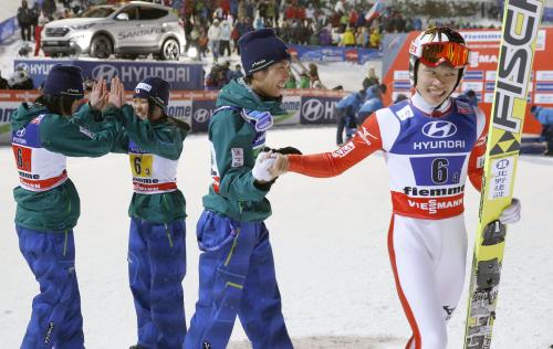 ノルディックスキー世界選手権のジャンプ混合団体で優勝し、タッチを交わす（左から）伊藤、高梨、伊東、竹内