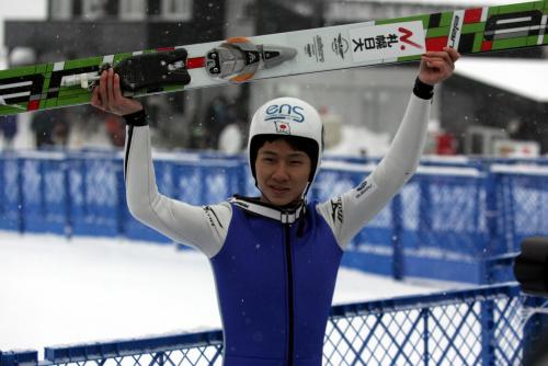 男子優勝の佐藤はスキー板を掲げて喜ぶ
