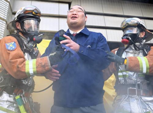 酸素マスクをつけ救助訓練に参加した振分親方（中）は、脱出に成功しホッとひと息