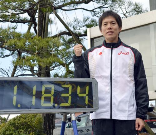 １時間18分34秒の日本新記録を示す掲示板の横でガッツポーズする鈴木雄介