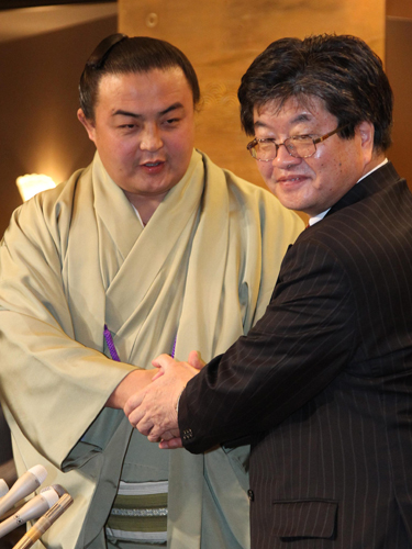会見を終えた蒼国来（左）は同席した小松弁護士と握手を交わす