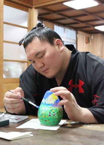福島県で生産された「起き上がりこぼし」に絵を描く白鵬