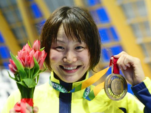 女子１００メートルバタフライで３位に入り、銅メダルを手に笑顔の小林奈央