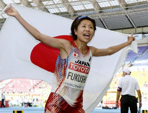 女子マラソンで銅メダルを獲得し、日の丸を掲げる福士加代子