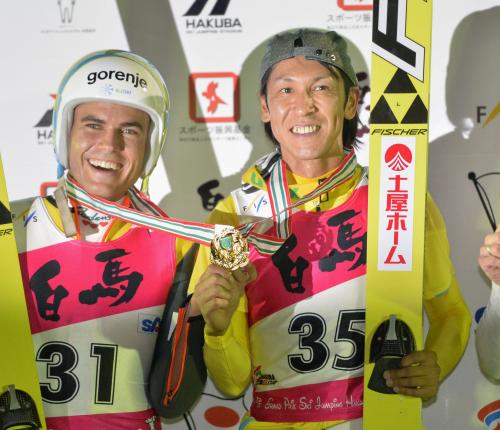 表彰式で同点優勝のヤルネイ・ダミャン（左）とメダルを重ねる葛西紀明