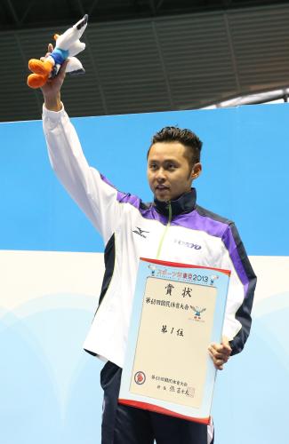 成年男子１００メートル平泳ぎ決勝を制して、表彰台で東京国体のマスコット・ゆりーとを手に声援にこたえる北島