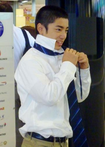 体操の世界選手権出発前、成田空港でネクタイを結ぶ17歳の白井健三