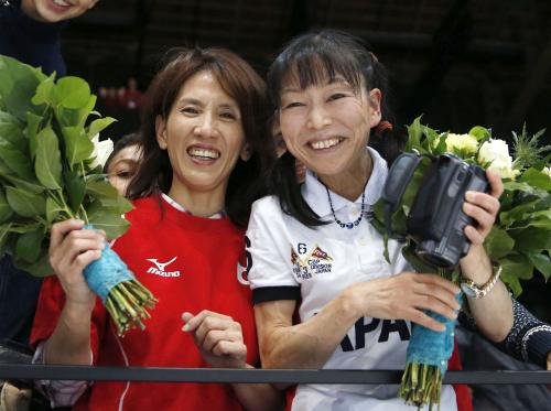 ３日、４連覇を果たした内村航平選手から受け取った花束を手に、笑顔を見せる母周子さん（右）と加藤凌平選手の母由美さん