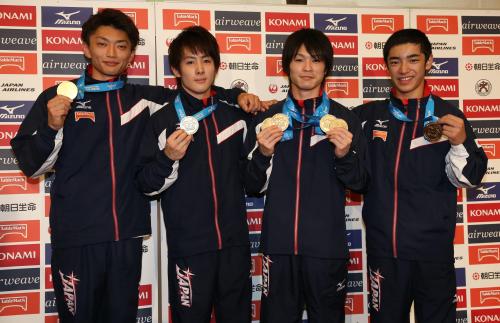 帰国会見で、メダルを手に笑顔の（左から）亀山、加藤、内村、白井