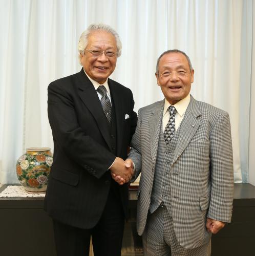 東京国際大の倉田理事長（左）と握手する三宅義信氏