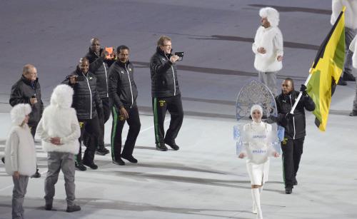 ソチ冬季五輪の開会式で、入場行進するジャマイカ選手団と、ミニスカート姿の先導の女性