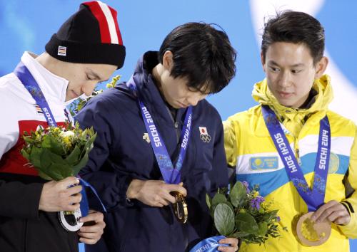フィギュアスケート男子の表彰式で、メダルの表裏を確認する（左から）銀のパトリック・チャン、金の羽生結弦、銅のデニス・テン