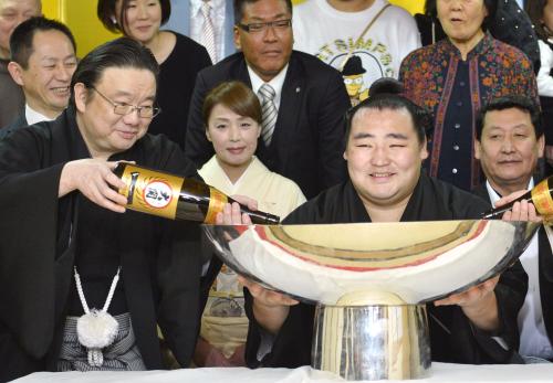 大相撲春場所で初優勝し、祝勝会で大杯を手に笑顔の大関鶴竜。左は井筒親方