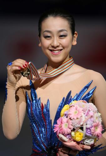 世界選手権で優勝し、金メダルを手に笑顔の浅田真央